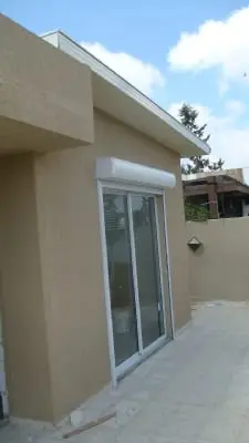 דלת הזזה ותריס לבן בפינת יחידת הדיור