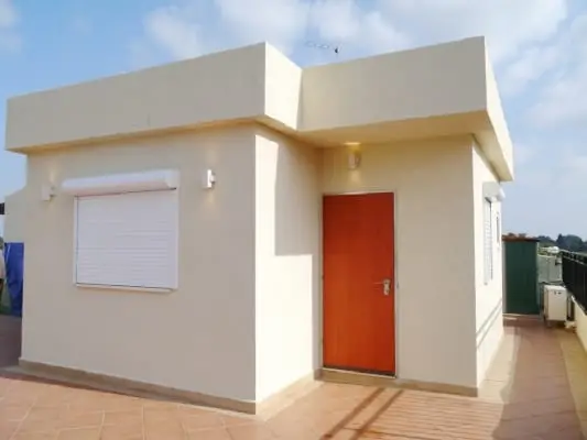 תוספת בניה קלה גמורה על גג, קירות טיח בגוון שמנת, תריס לבן ודלת עץ