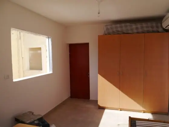 חדר פנימי בתוספת עם קירות לבנים, חלון וארון קיר